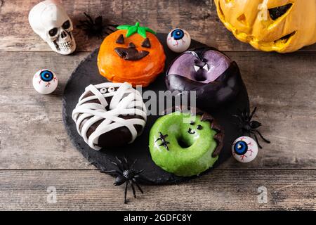 Assortmen von Halloween Donuts auf Holztisch Stockfoto