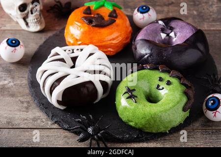 Assortmen von Halloween Donuts auf Holztisch Stockfoto