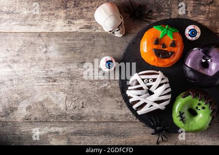 Assortmen von Halloween Donuts auf Holztisch Stockfoto