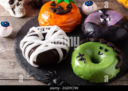 Assortmen von Halloween Donuts auf Holztisch Stockfoto