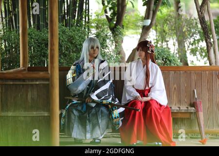 Asiatische Mädchen Porträt, japanische Miko in der Natur mit Samurai Cosplay Stockfoto