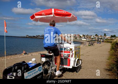 Mobiles Fahrrad mit farbigem Regenschirm, der Eis verkauft, in hampton in der Nähe der Küstenstadt herne Bay im Osten von kent, großbritannien, august 2021 Stockfoto