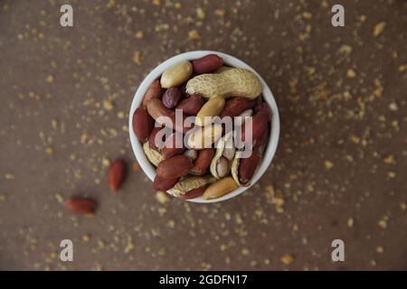 Erdnüsse in Muscheln auf Holzhintergrund Stockfoto
