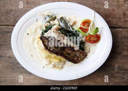 Grillen Sie Seebarschfilets mit zerkleinerten Kartoffeln Stockfoto