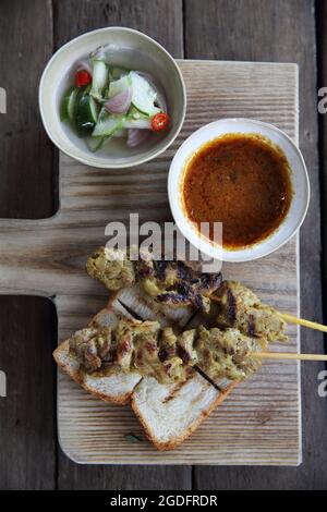 Malaysisches Essen Hähnchensatay mit Erdnusssauce auf Holzhintergrund Stockfoto