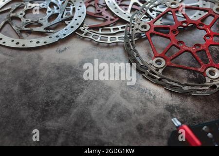 Abgenutzte Mountainbike-Bremsscheiben liegen in der Werkstatt. Stockfoto