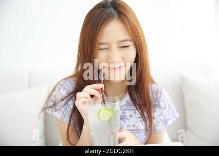 Frau trinkt Limettensaft im weißen Coffeeshop Stockfoto