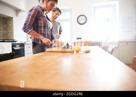 Paar schneiden frisches Obst am Küchentisch Stockfoto