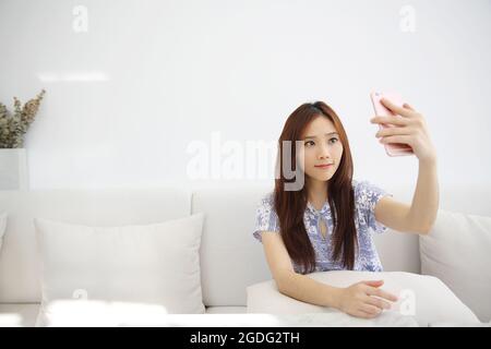 Junge schöne Frau Foto Selfie in weißem Ton Stockfoto