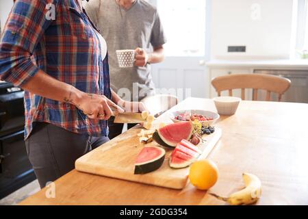 Paar schneiden frisches Obst am Küchentisch, mittlerer Abschnitt Stockfoto