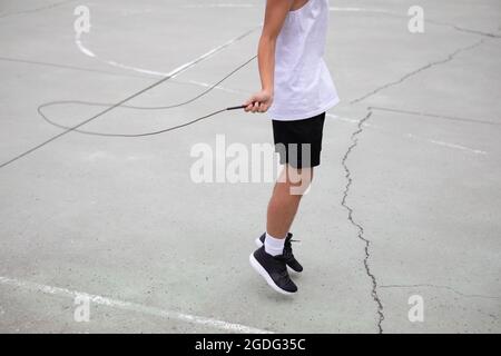 Männliche Teenager basketball Player auf Basketballplatz überspringen, Hals nach unten Stockfoto