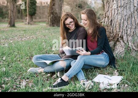 Freundinnen Buch in Park Stockfoto