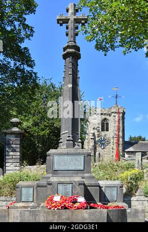 Erinnerung Ende des Ersten Weltkriegs Red Mohn Kaskade fällt von oben St Andrews Church Uhrenturm hinter Krieg Gedenkkränze Kildwick Yorkshire uk Stockfoto