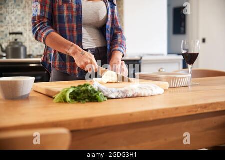 Frau schneiden Zwiebel am Küchentisch, mittlerer Abschnitt Stockfoto