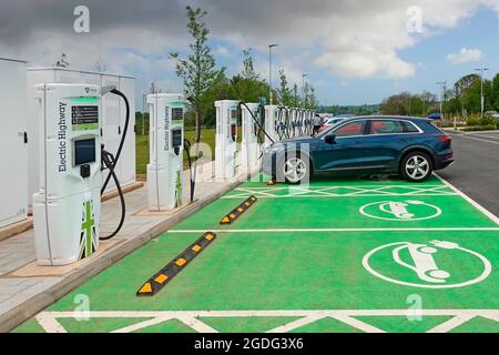 Elektroauto auf grünem Parkplatz zum Aufladen an Electric Highway350kW Ladegeräten auf der neuen MOTO Rugby Service Station M6 Autobahn Warwickshire England Vereinigtes Königreich Stockfoto