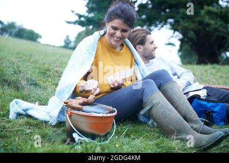 Paar im ländlichen Bereich Kochen am Grill zubereitet Stockfoto