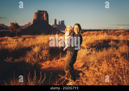 Eine Frau mit einem Baby steht im Monument Valley, Arizona Stockfoto