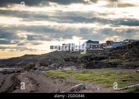 Einzigartige Häuser auf einer Klippe mit Blick auf den Ozean in Iqaluit, Kanada. Stockfoto