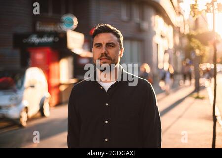 Nachdenklicher Mann, der im Sommer auf der Straße in der Stadt herumläuft Stockfoto