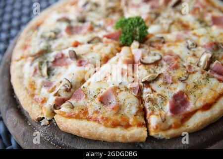 Pizzaschinken und Pilze auf Holz Stockfoto