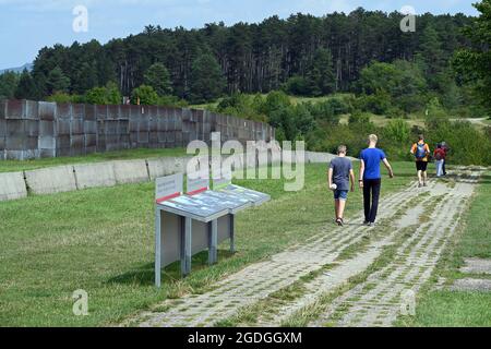 Geisa, Deutschland. August 2021. Am Point Alpha Denkmal spazieren Besucher entlang des ehemaligen Kolonnenwegs neben einem Grenzzaun. Zum Gedenken an den Bau der Berliner Mauer vor 60 Jahren und die innerdeutsche Teilung wurde eine Gedenkveranstaltung abgehalten. Quelle: Swen Pförtner/dpa-Zentralbild/dpa/Alamy Live News Stockfoto