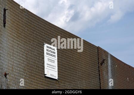 Geisa, Deutschland. August 2021. An einem Grenzzaun an der Point Alpha-Gedenkstätte ist ein Schild 'Denkmal für die deutsche Geschichte' angebracht. Zum Gedenken an den Bau der Berliner Mauer vor 60 Jahren und die innerdeutsche Teilung wurde eine Gedenkveranstaltung abgehalten. Quelle: Swen Pförtner/dpa-Zentralbild/dpa/Alamy Live News Stockfoto