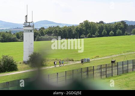 Geisa, Deutschland. August 2021. Blick auf einen ehemaligen Aussichtsturm hinter einem Grenzzaun an der Point Alpha Gedenkstätte. Zum Gedenken an den Bau der Berliner Mauer vor 60 Jahren und die innerdeutsche Teilung wurde eine Gedenkveranstaltung abgehalten. Quelle: Swen Pförtner/dpa-Zentralbild/dpa/Alamy Live News Stockfoto