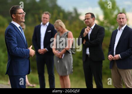 Geisa, Deutschland. August 2021. Christian Hirte (CDU, l), Vorsitzender der CDU Thüringen, spricht bei einer Gedenkveranstaltung der Thüringer CDU zum Gedenken an den Bau der Berliner Mauer vor 60 Jahren und die innerdeutsche Division am Gedenkpunkt Alpha vor Kränzen am Denkmal der innerdeutschen Division. Quelle: Swen Pförtner/dpa-Zentralbild/dpa/Alamy Live News Stockfoto