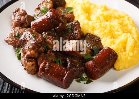 Traditionelle rumänische Gericht Pomana porcului Auswahl an Schweinefleisch, Würstchen mit Mammaliga close-up in einem Teller auf dem Tisch. Horizontal Stockfoto