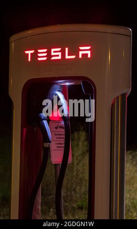 Ponferrada Outskirts, Spanien - 09. August 2021: Tesla-Kompressorstation bei Nacht. Tesla ist ein amerikanisches Unternehmen für Elektrofahrzeuge und saubere Energie Stockfoto