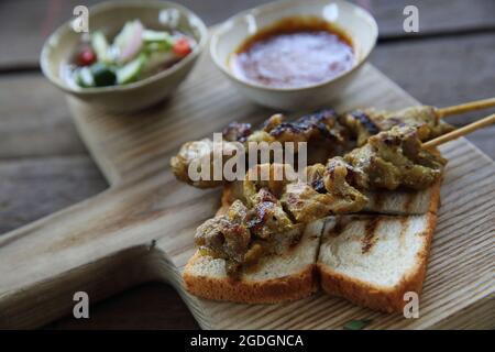 Malaysisches Essen Hähnchensatay mit Erdnusssauce auf Holzhintergrund Stockfoto