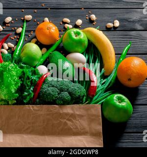 Papiertüte mit verschiedenen tropischen frischen Früchten und Gemüse. Gesundes Essen und Lebensmitteleinkauf Konzept. Draufsicht Stockfoto