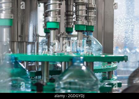 Automatisches Abfüllen von Trinkwasser in fünf-Liter-Plastikflaschen. Lebensmittelproduktion Stockfoto