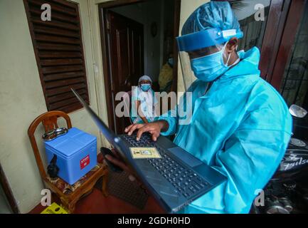 Colombo, Sri Lanka. August 2021. Gesundheitsbeamte der srilankischen Armee bereiten sich darauf vor, eine Frau für die Einnahme einer Dosis des Covid-19-Coronavirus während einer mobilen Impfkampagne durch Gesundheitsbeamte der Armee in Colombo zu registrieren. (Bild: © Pradeep Dambarage/ZUMA Press Wire) Bild: ZUMA Press, Inc./Alamy Live News Stockfoto