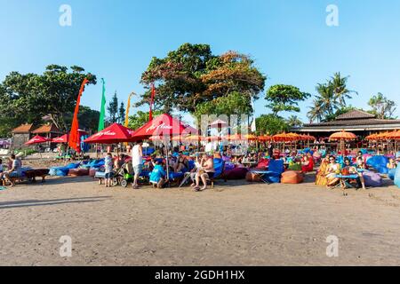 Kuta, Indonesien - 14. September 2018: Touristen und Einheimische bummeln und genießen den Sonnenuntergang am Seminyak-Strand auf Bali. Es ist eine der Touristenattraktionen in Stockfoto