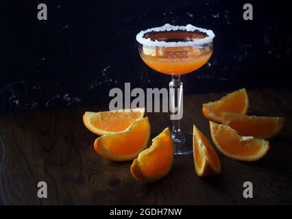 Orangencocktail im Glas mit Zucker. Erfrischender, alkoholischer Sidecar-Cocktail mit einem Zuckerrand und Zitrusfrüchten Stockfoto
