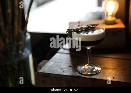 Kaffeecocktail mit Kaffeebohne und Rosmarin auf der Oberseite mit Holzhintergrund Stockfoto