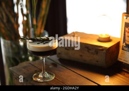 Kaffeecocktail mit Kaffeebohne und Rosmarin auf der Oberseite mit Holzhintergrund Stockfoto