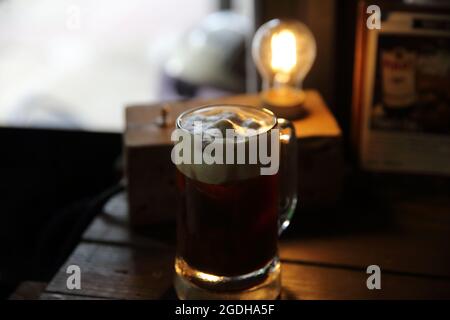 Kaffeecocktail mit Kaffeebohne und Rosmarin auf der Oberseite mit Holzhintergrund Stockfoto