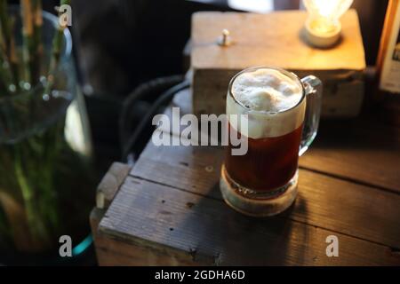 Kaffeecocktail mit Kaffeebohne und Rosmarin auf der Oberseite mit Holzhintergrund Stockfoto