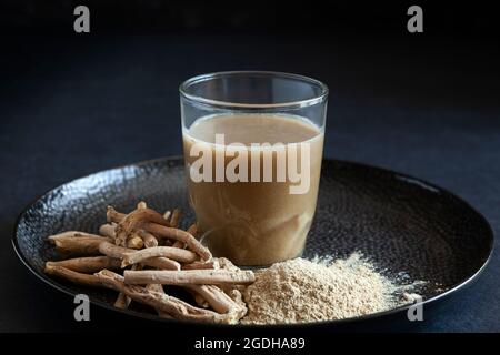 Trockene Ashwagandha-Wurzel, auch bekannt als Withania Somnifera, Indischer Ginseng, Giftbeere oder Winterkirsche auf dunklem Hintergrund. Stockfoto