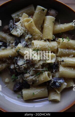 Pasta Pilz Trüffelöl auf Holz Hintergrund , Rigatoni Pasta Nudel mit Trüffelöl Pilz und Käse , italienische Küche Stockfoto