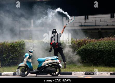 Bangkok, Thailand. August 2021. Ein Protestler trifft während der Demonstration eine Tränengasgranate mit einem Tennisschläger, um Polizisten aufzurührern. Die Polizei in Bangkok feuerte Gummigeschosse und Tränengas auf prodemokratische Demonstranten, die den Premierminister Prayut Chan-o-cha zum Abtreten forderten und die Regierung für ihr grobes Missmanagement der Covid-19-Pandemie zur Verantwortung ziehen sollten. Kredit: SOPA Images Limited/Alamy Live Nachrichten Stockfoto