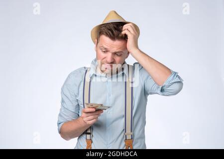 Junger Geschäftsmann hält und zählt Geldscheine in den Händen Stockfoto