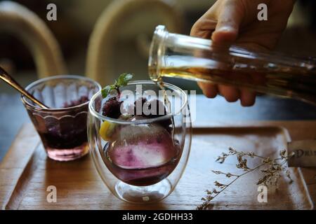 Beeren Tee mit Eiskugel auf Holz Hintergrund Stockfoto