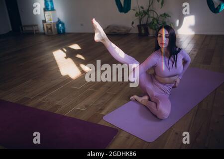 Frau, die im Studio Luftyogas macht. Frau, die Luft Yoga in der Hängematte praktiziert. Stockfoto