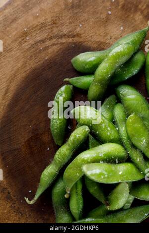 Grüner Edamame mit Salz auf Holzplette Stockfoto