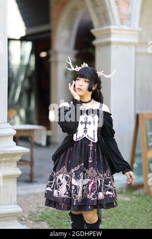 Portrait von asiatischen Mädchen in Lolita Mode Kleid im Jahrgang Gartenhintergrund Stockfoto