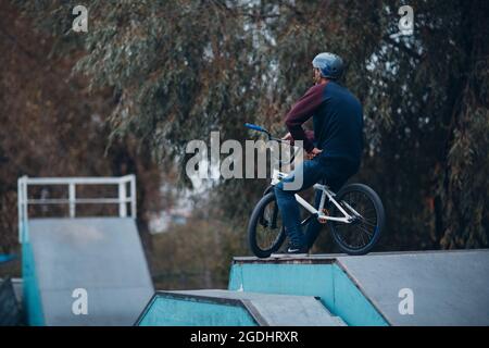 Professioneller junger Sportler Radfahrer, der im Skatepark Mini-Bike fährt Stockfoto