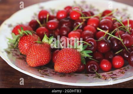 Erdbeeren und Kirschen auf einem Teller. Beerenernte Stockfoto